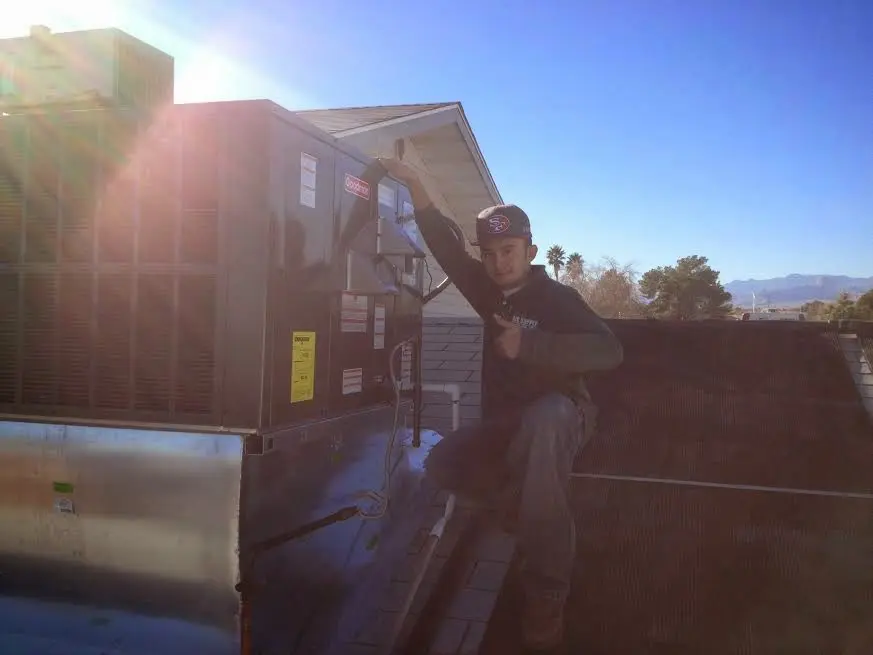 HVAC technician performing Air Duct Cleaning on a rooftop unit in Glenn Dale