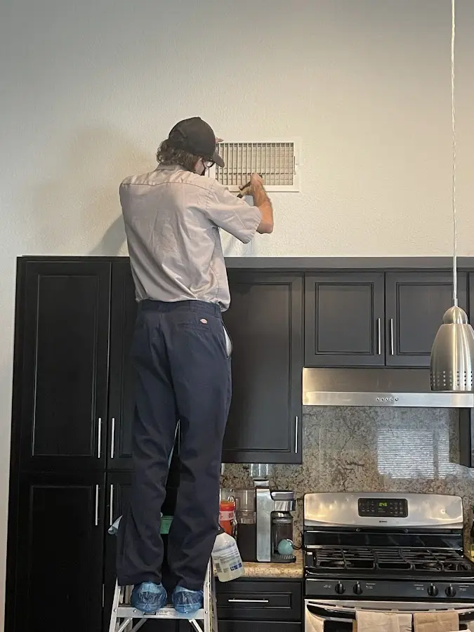 Technician inspecting an air vent during HVAC service in Glenn Dale